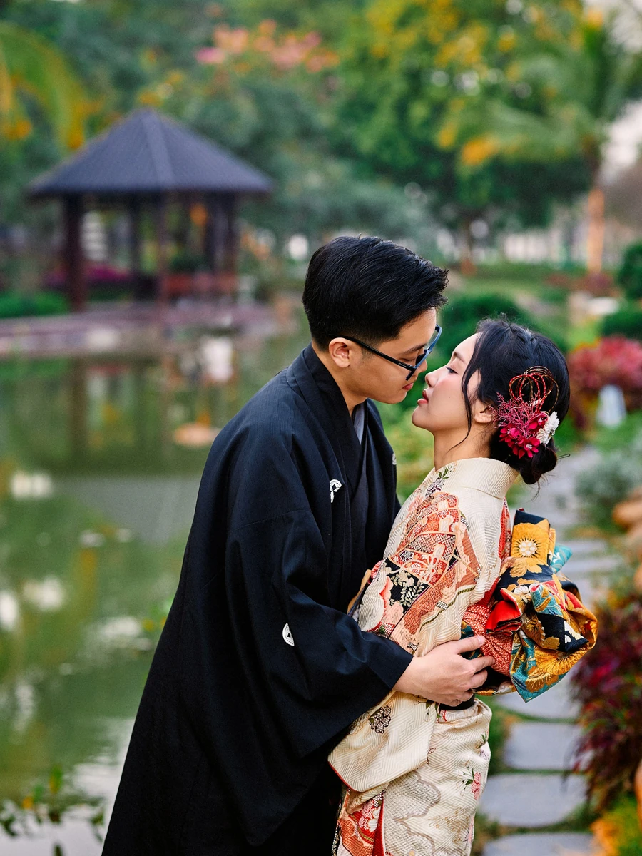 Pasangan berbusana tradisional di taman; foto stok