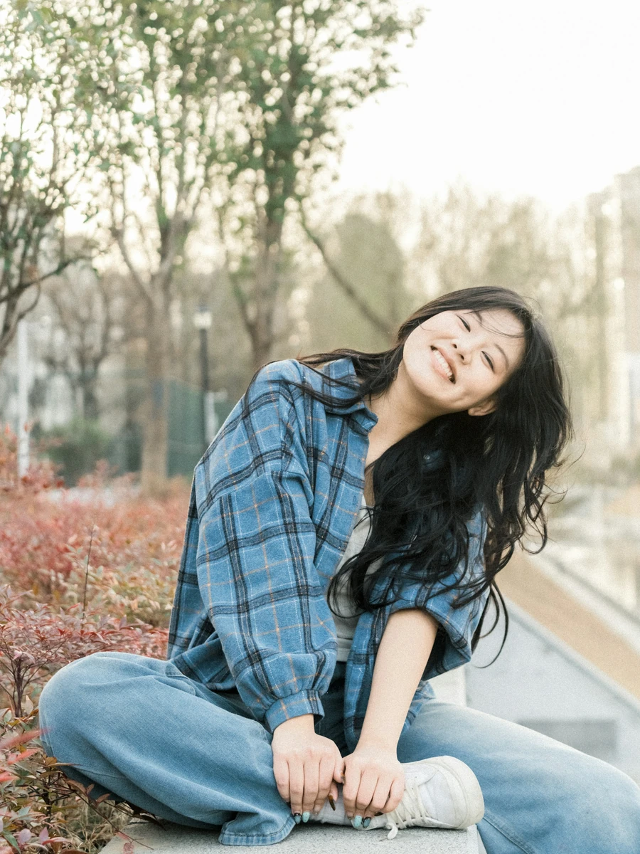 Perempuan tersenyum di luar ruangan; foto stok